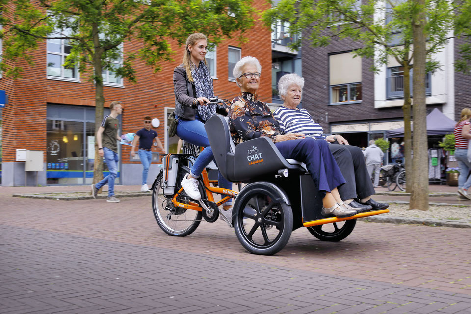 Eine Frau fährt zwei ältere Damen im Van Raam Chat spazieren