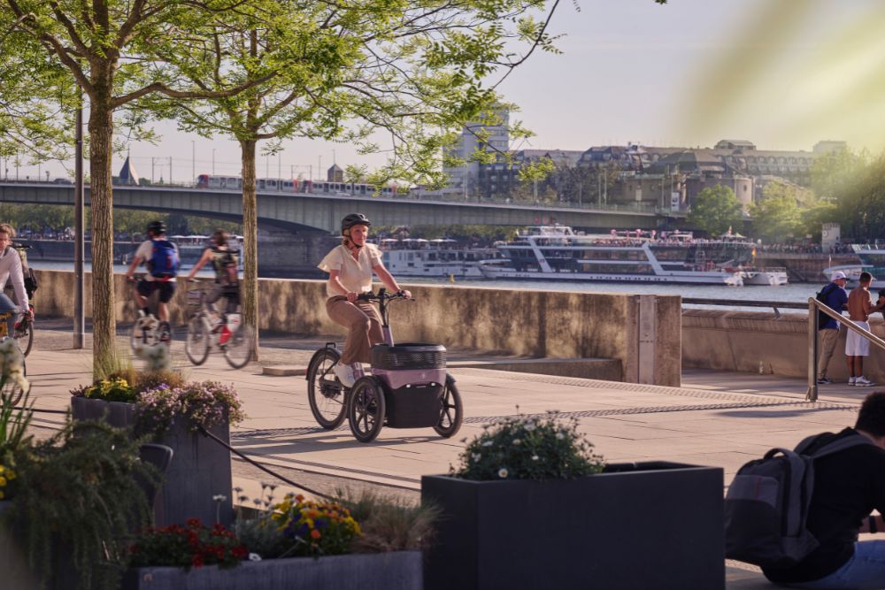 Eine Frau fährt am Rhein entlang mit ihrem Thuja von vanRaam