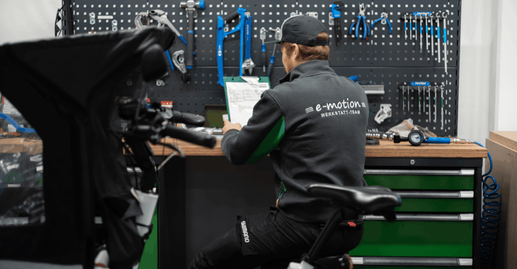 Ein Service Mitarbeiter sitzt in der Werkstatt mit einer Checkliste