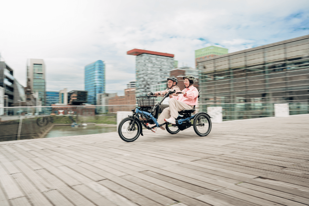 Zwei Personen fahren mit dem Hase Bikes Kettwiesel über eine Brücke